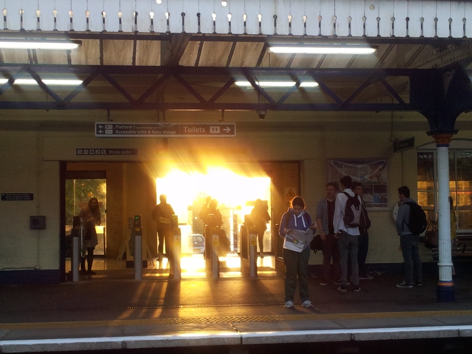 The sun rises directly behind the main entrance to Winchester station 